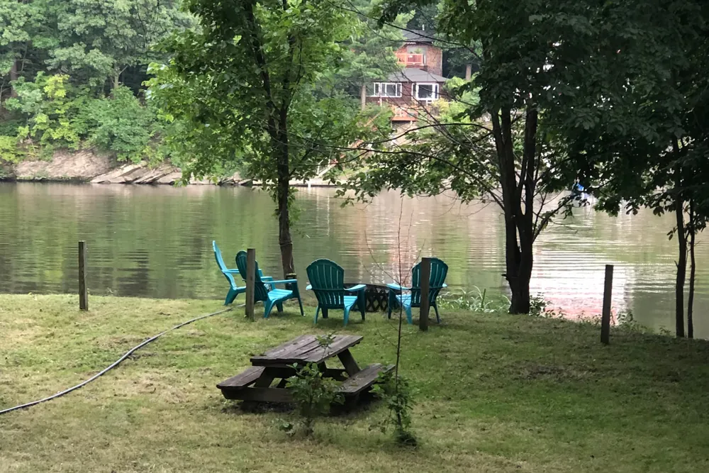 Chairs and picnic table by the river at Cabin 4